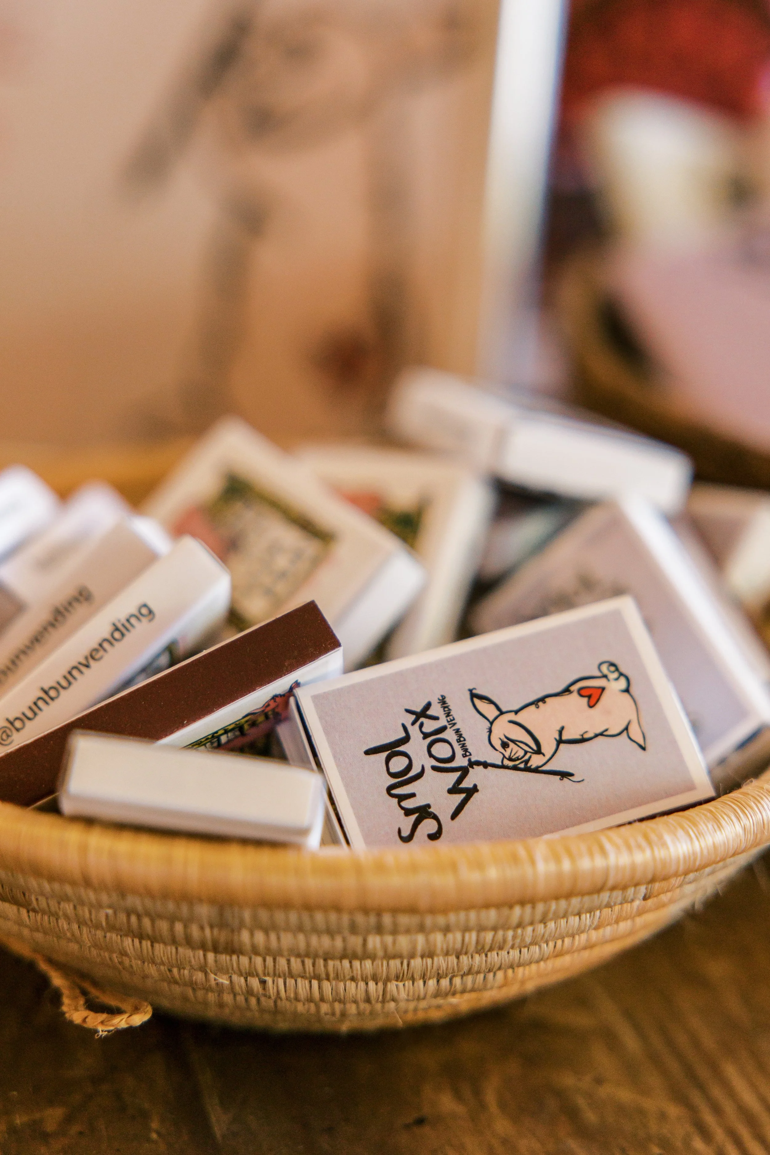 A wicker basket filled with multiple small boxes, one of which features a cartoon unicorn with a heart on its side on the cover.