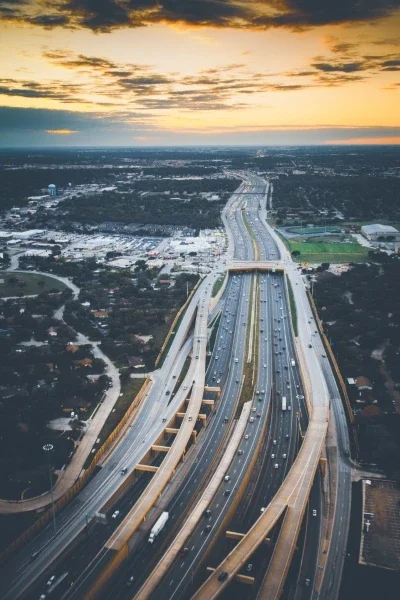 Birds eye view of highway with multiple levels and lanes in suburban area