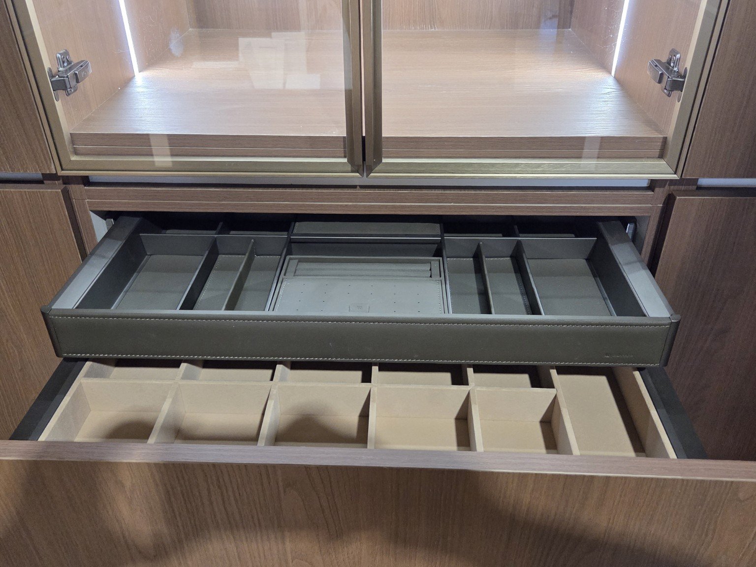 Open wooden cabinet with two drawers, one with compartments and the other with a soft closing drawer.