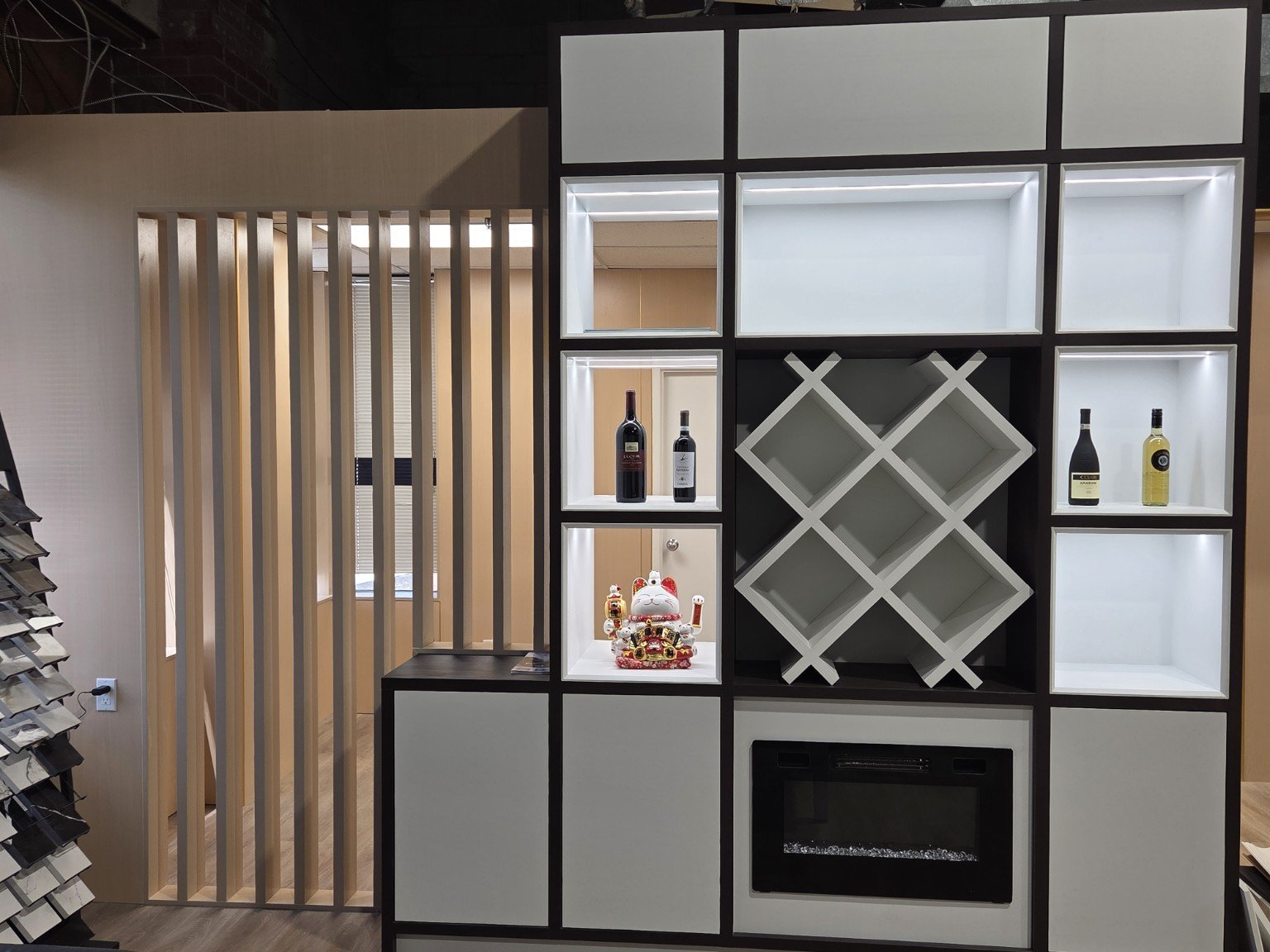 Modern shelving unit with wine bottles, a decorative cat, and wine rack, part of interior decor.