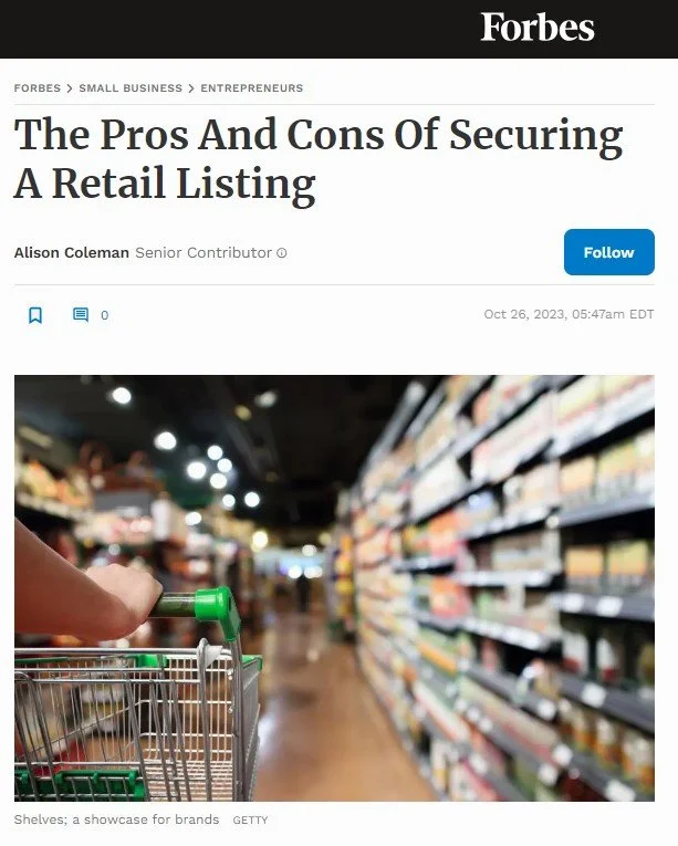 A person pushes a shopping cart down an aisle in a grocery store, with shelves stocked with various products on both sides.