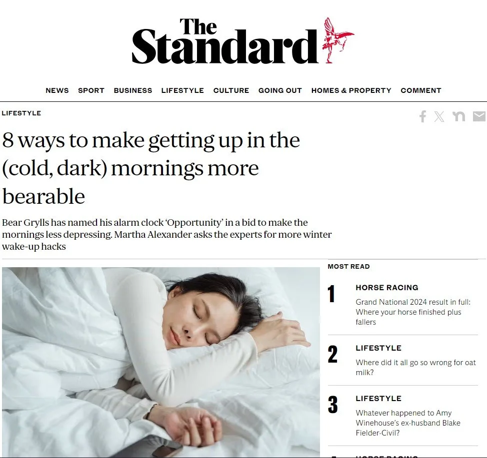 A woman sleeping on a white bed with her head resting on her arm. She has dark hair and is wearing a white long-sleeve shirt.