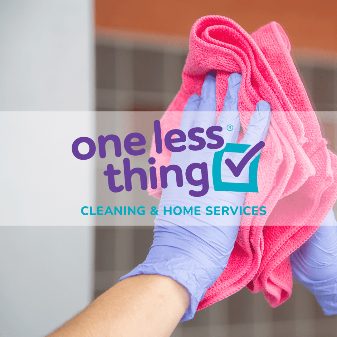 Person wearing gloves holding a pink cleaning cloth for cleaning a surface.