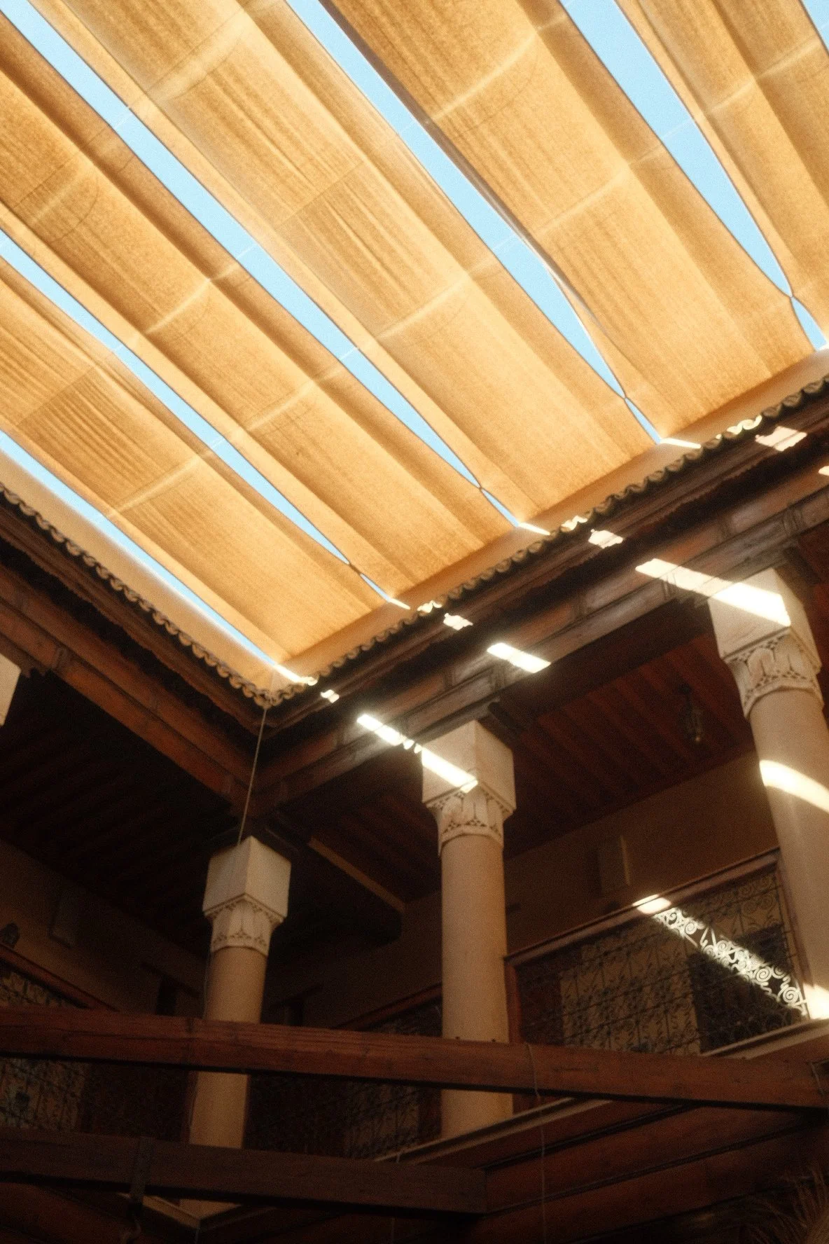 View of wooden ceiling slats with blue sky visible through gaps.