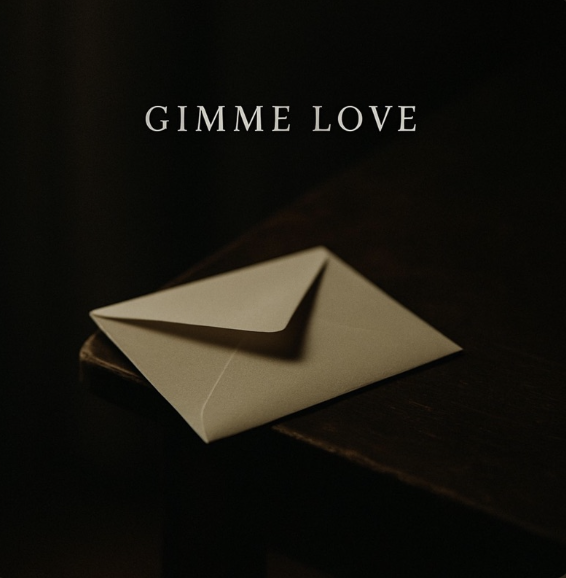 A beige envelope on a dark wooden surface with the text 'GIMME LOVE' above it.