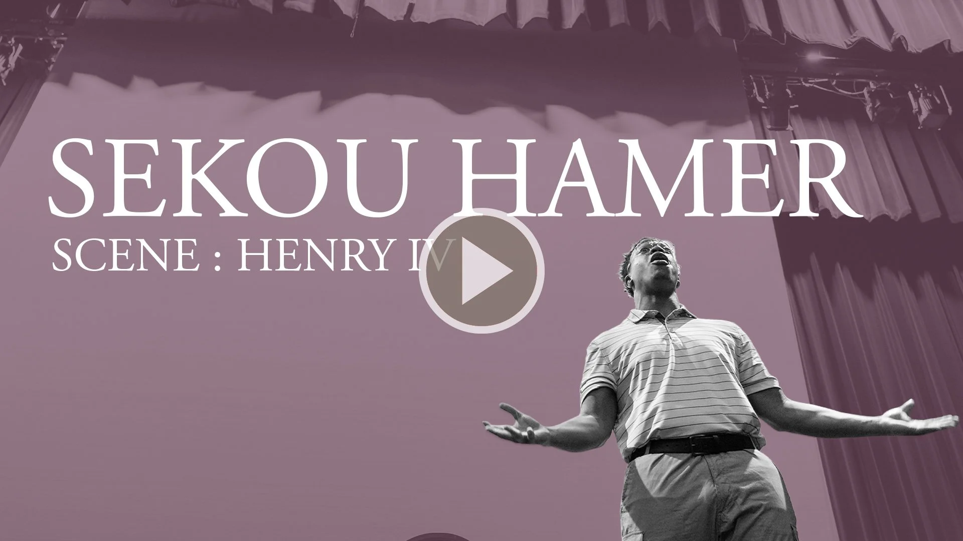 A scene from a theatrical performance titled 'Sekou Hamer,' featuring a male actor on stage with arms outstretched, standing in front of purple curtains and a backdrop with large, bold text.