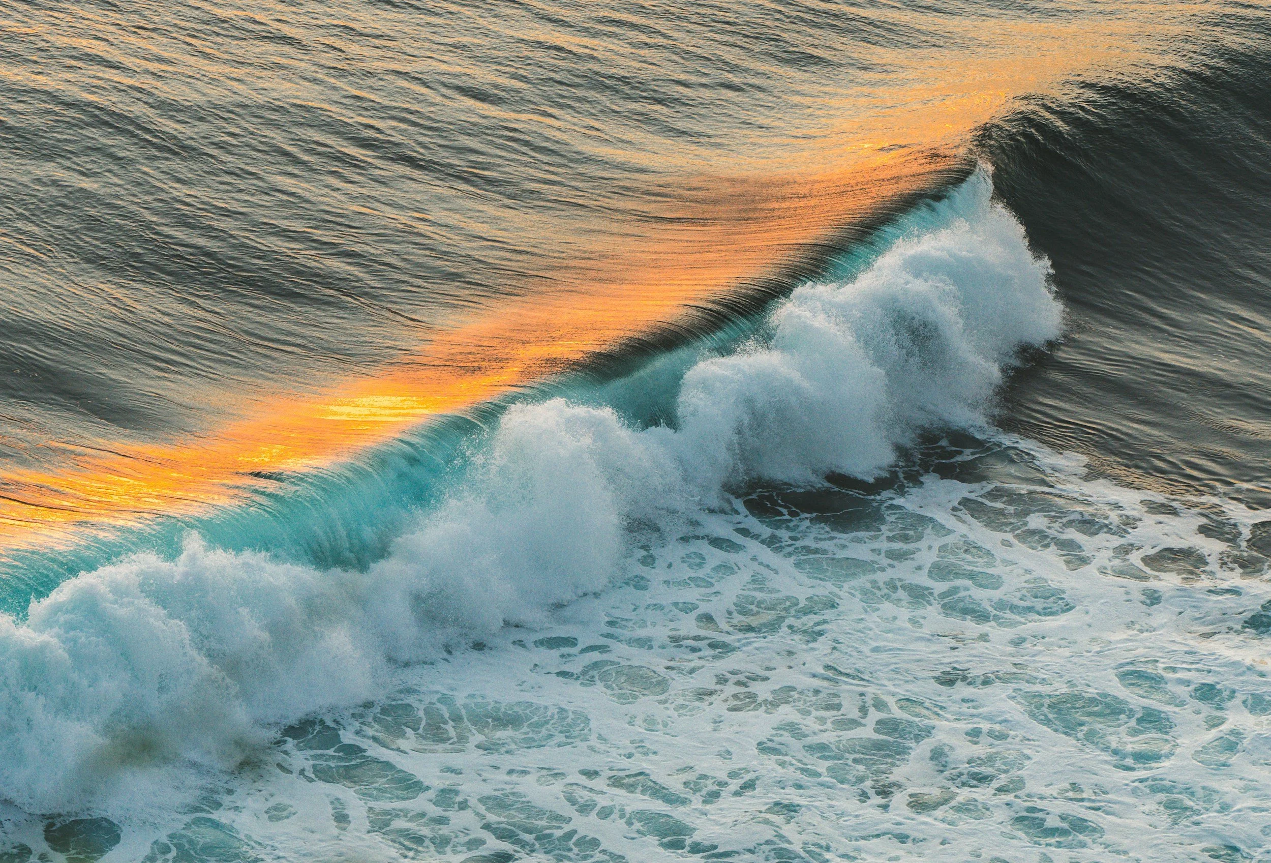 Peaceful ocean wave gently cresting at sunset, symbolizing calm, healing, and emotional resilience