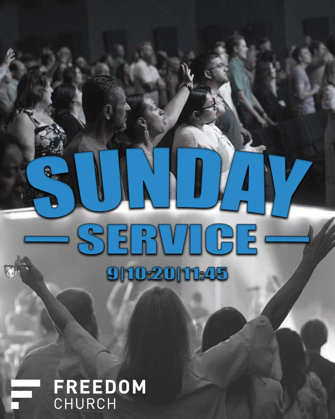 People attending a church service with a large screen displaying information about Sunday service at Freedom Church, including the date and time, with a woman raising her hand in the congregation.