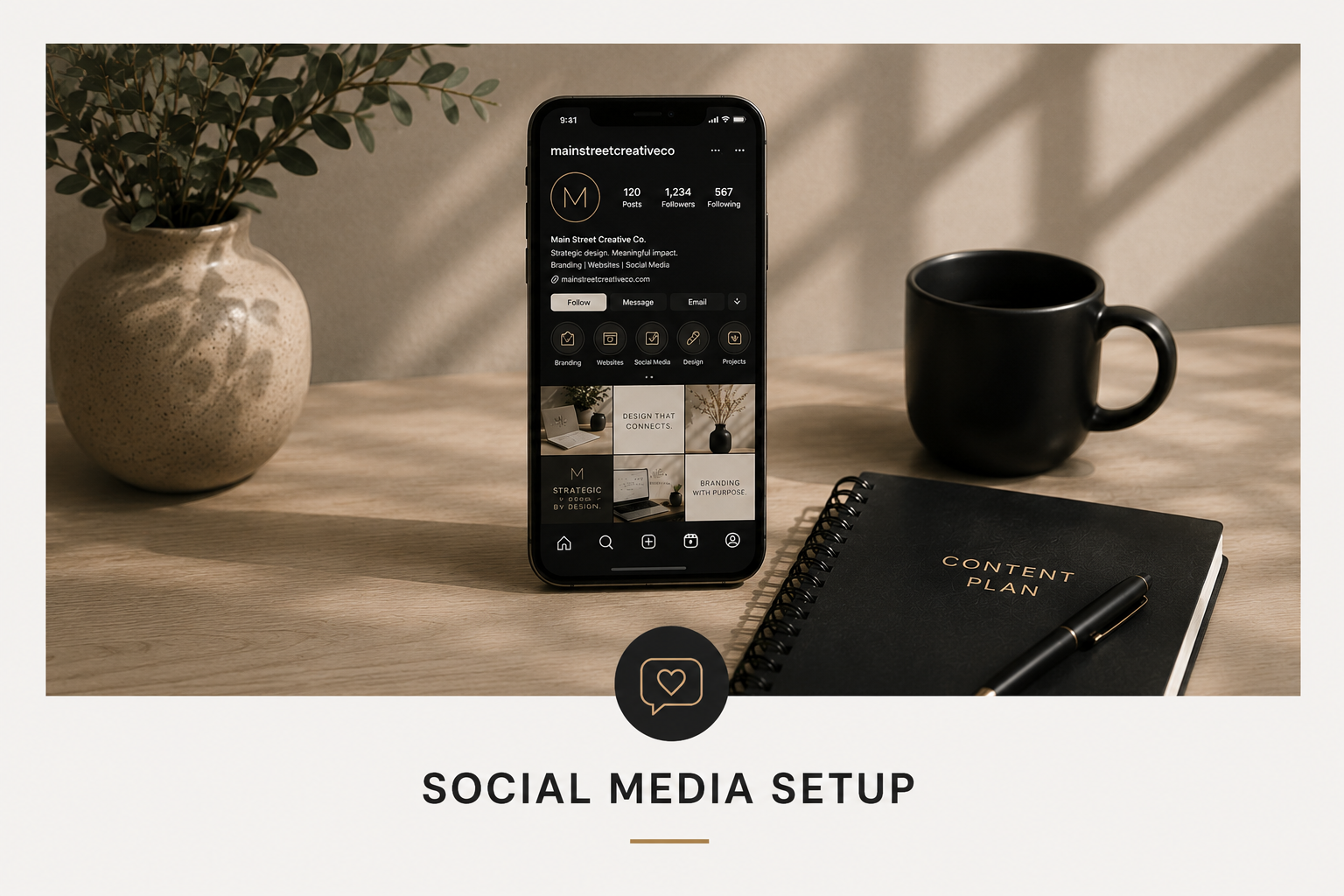 A social media setup on a wooden desk includes a smartphone displaying an Instagram profile, a black coffee mug, a black content plan notebook with a pen, and a beige vase with green leaves, with soft shadows and natural lighting.