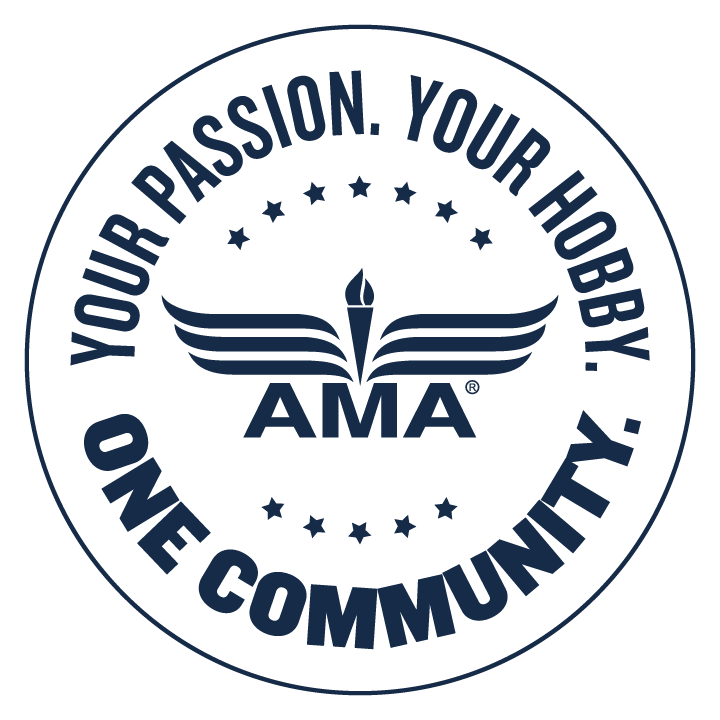 A circular logo with the text 'Your Passion, Your Hobby, One Community' around the circumference. Inside the circle, there is a stylized open book with wings and a flame at the center, with the acronym 'AMA' beneath the flame.