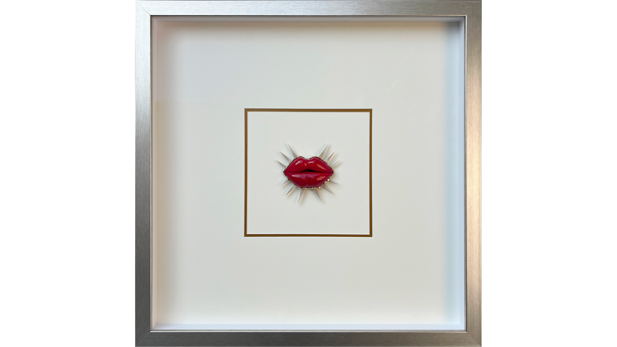 Framed artwork featuring red lips with white spikes radiating outward, set against a white background with a gold rectangular outline.