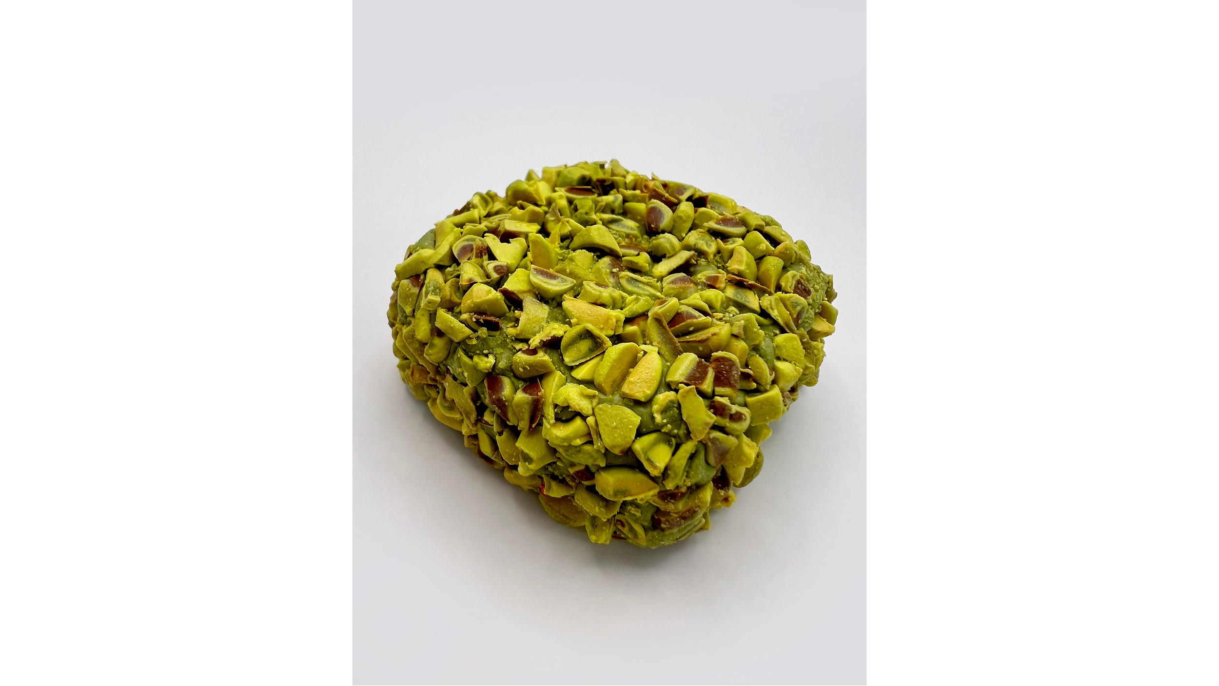 A round ball of chopped pistachios on a white background.