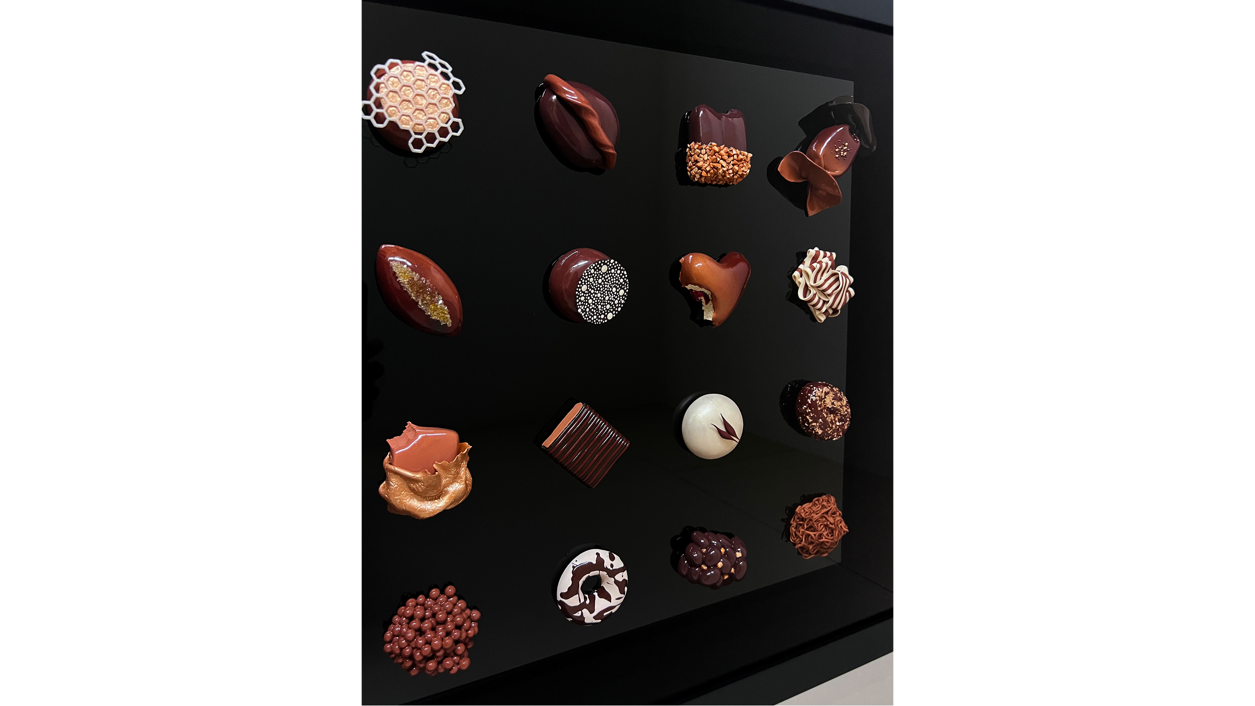 Assorted chocolates and confections displayed on a black surface.