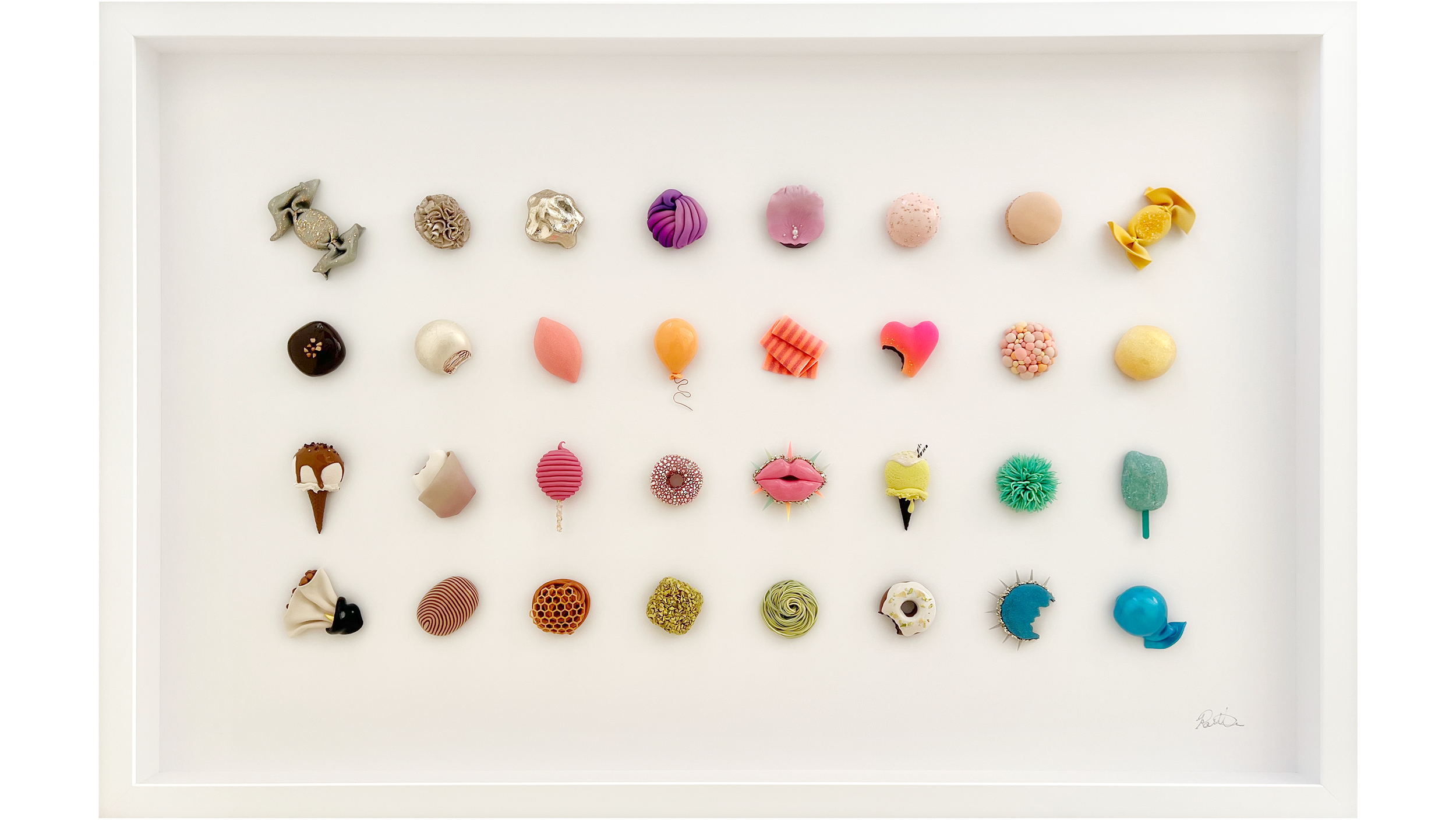 An art display of colorful, creative confections arranged in rows on white background, resembling an art piece.