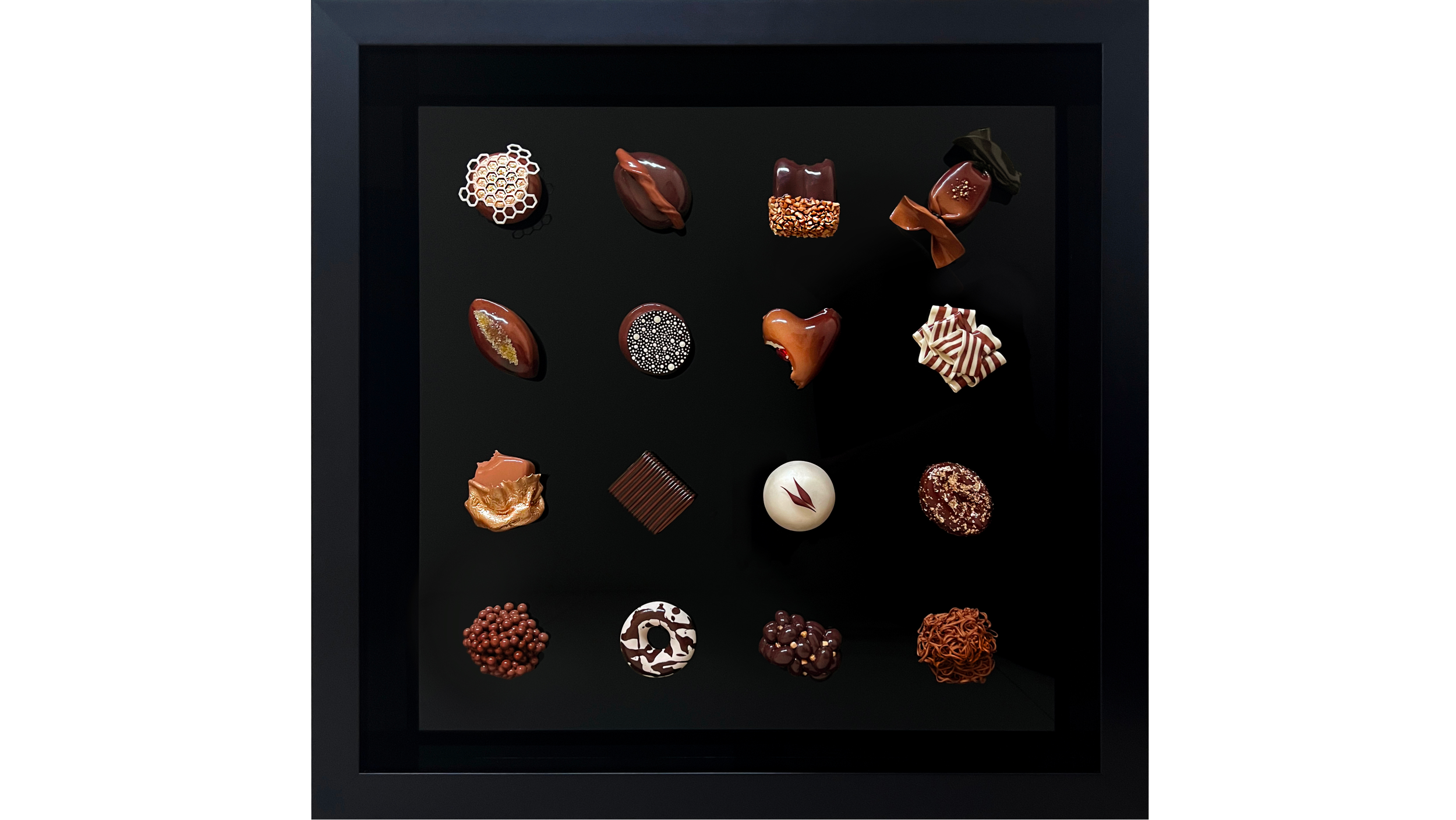 A black display case filled with various assorted chocolates and confections, arranged in rows.