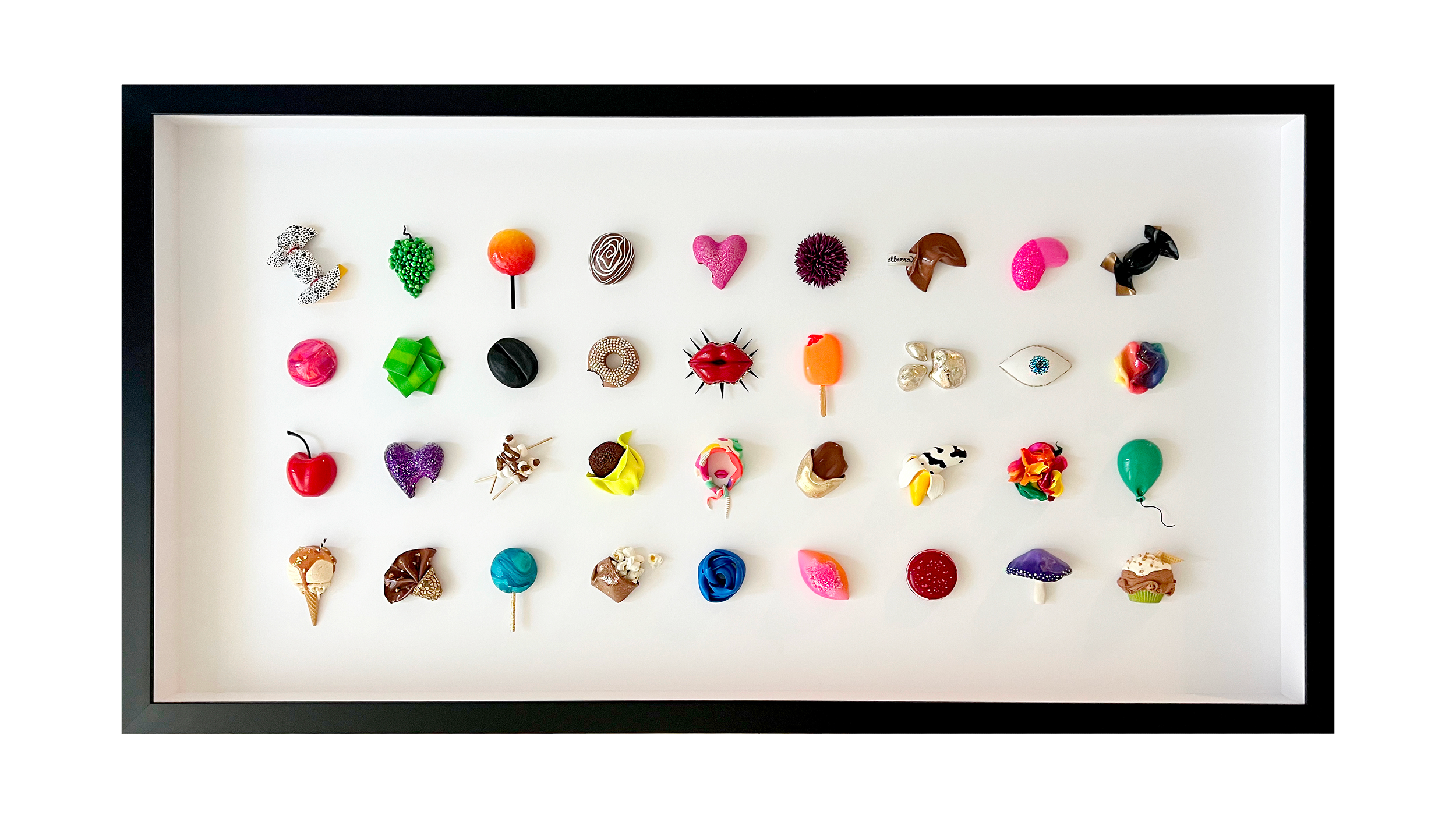 Display of assorted colorful candies and chocolates arranged on a white background.