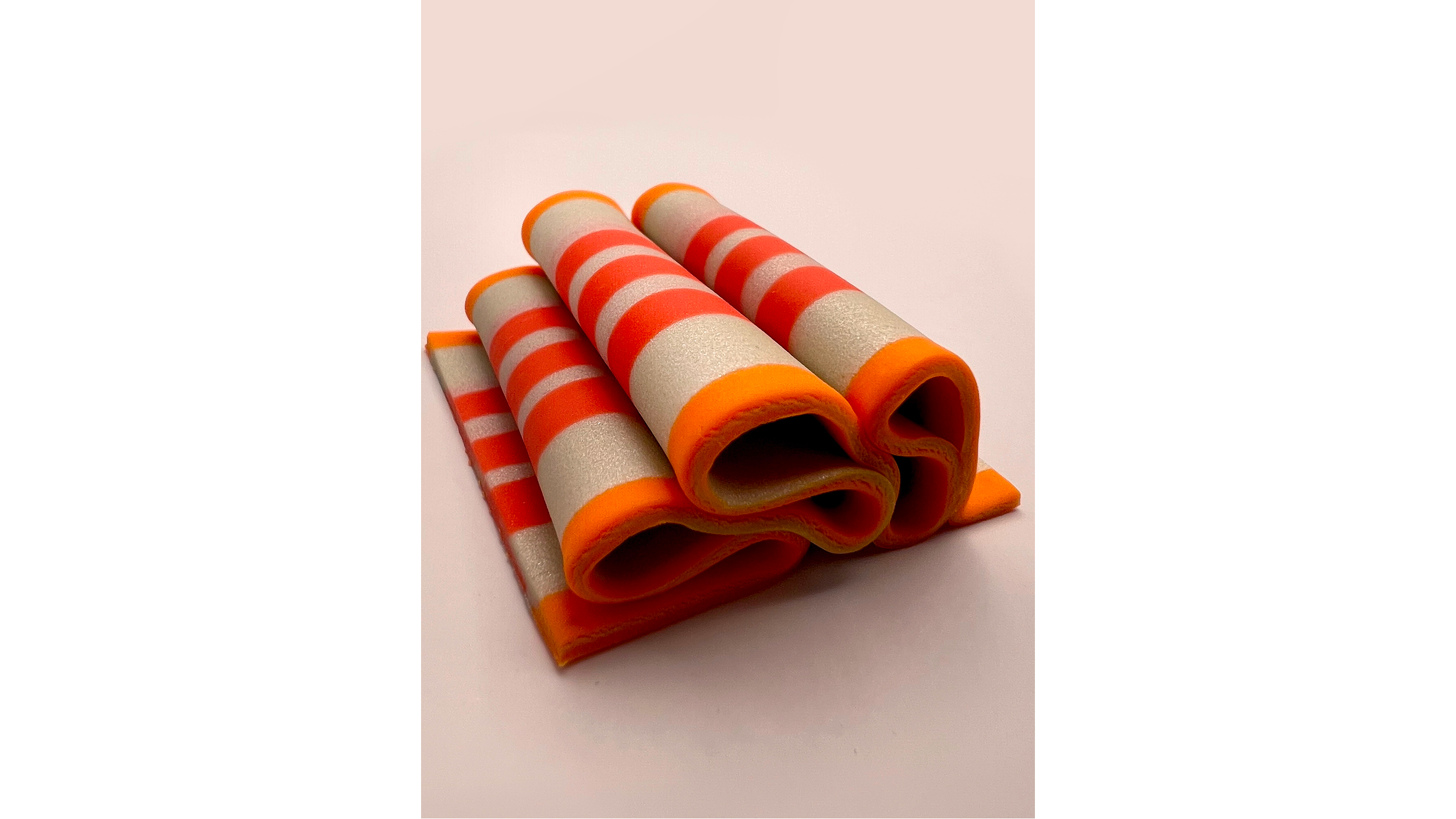 Stack of orange and white striped gummy candies served in a spiral shape on a plain background.