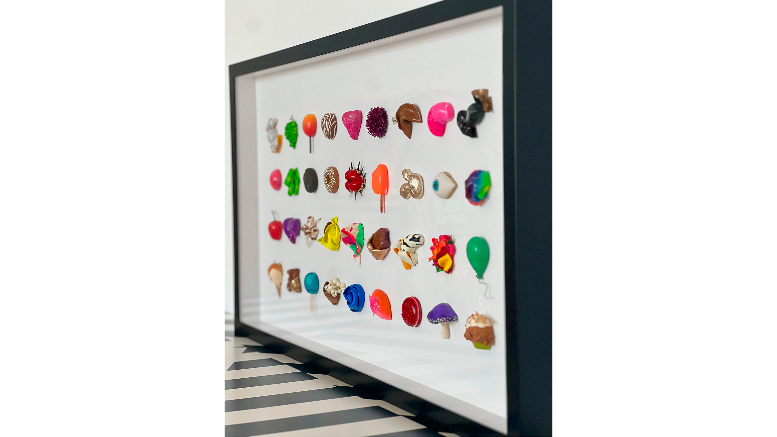 Colorful assorted earrings displayed in a shadow box frame.