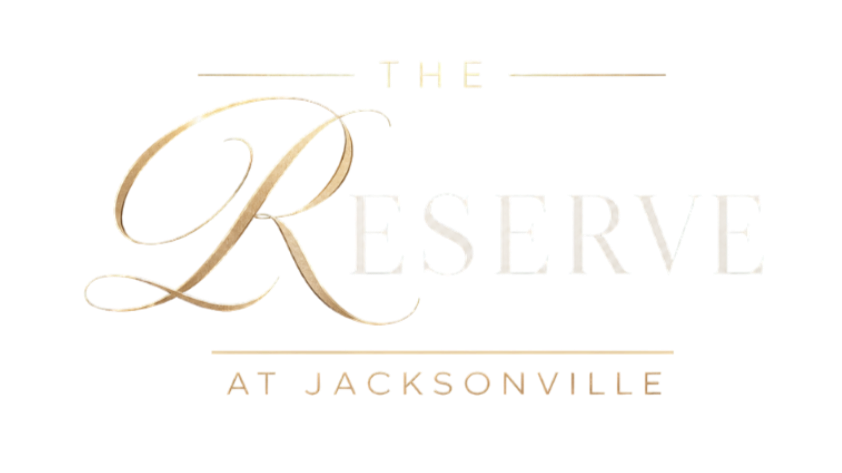 Logo for The Reserve at Jacksonville with stylized text and a gold-lined uppercase font.