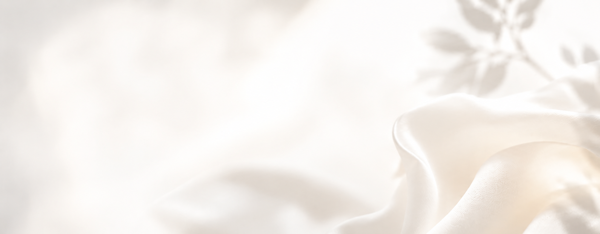 Close-up of silky, creamy white fabric with soft folds and gentle sheen.