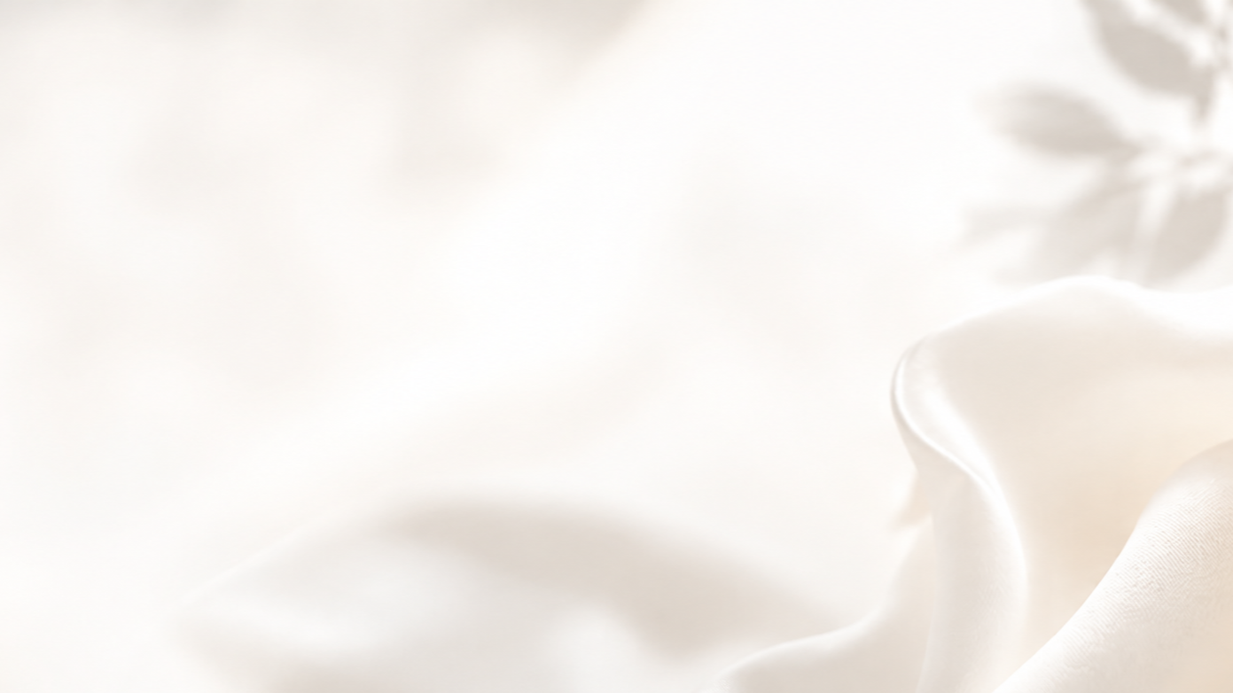 Close-up of white silk fabric with soft folds and gentle curves.