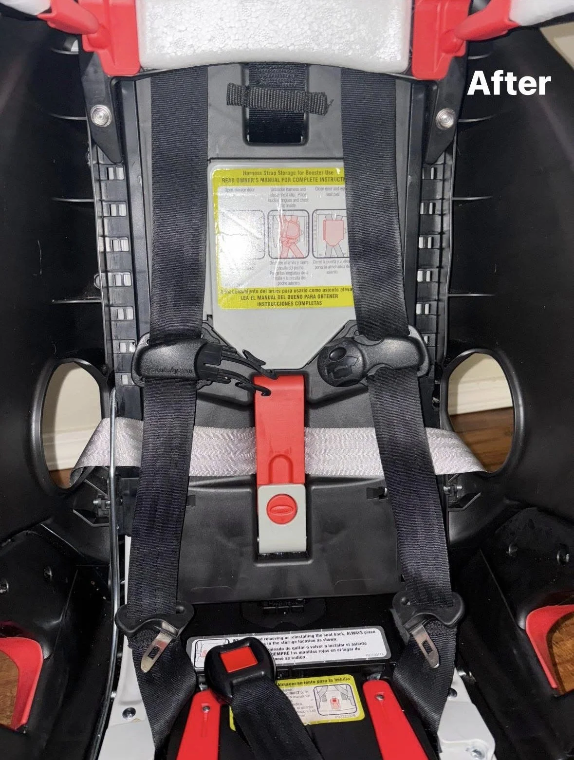 The inside of a child car seat showing the harness straps, buckle, and seat instructions.