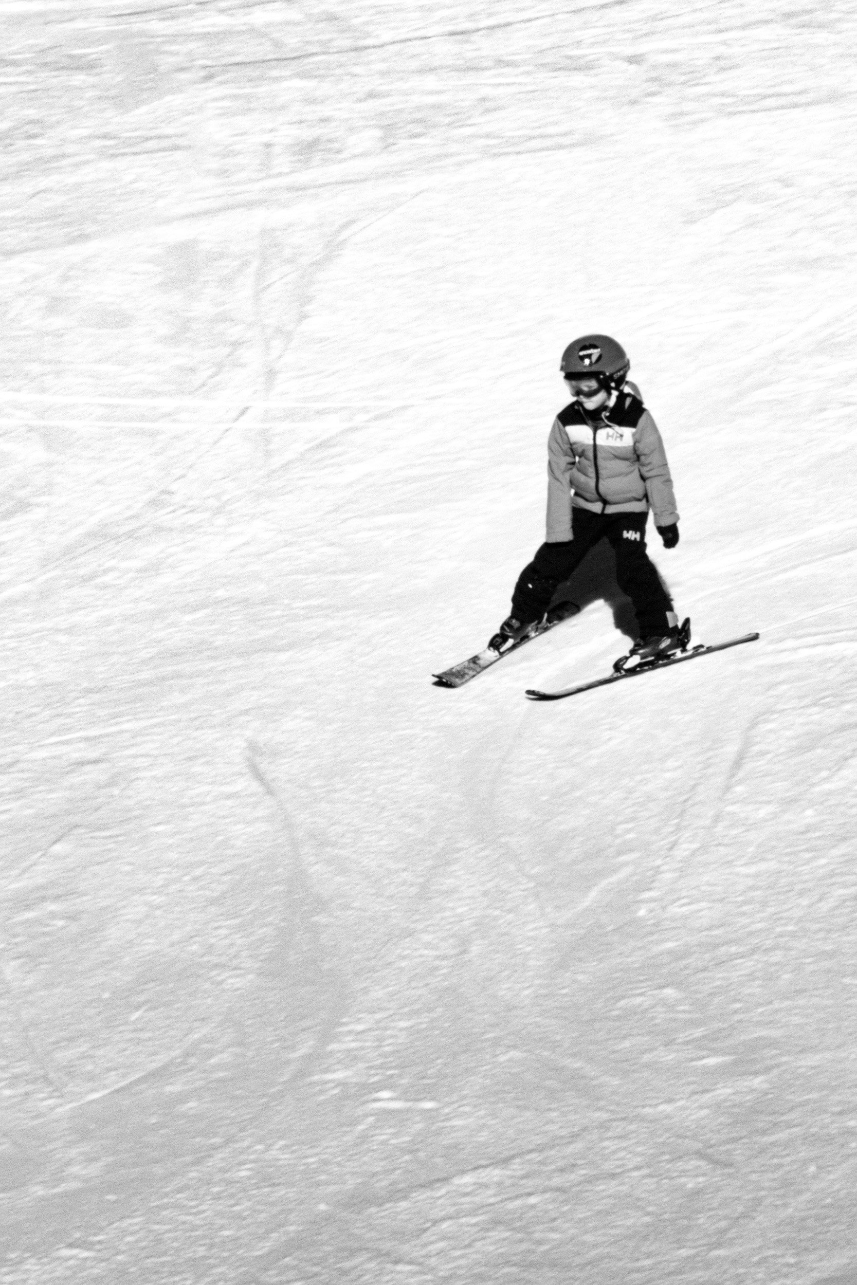 A person wearing winter gear snowboarding down a snowy slope.