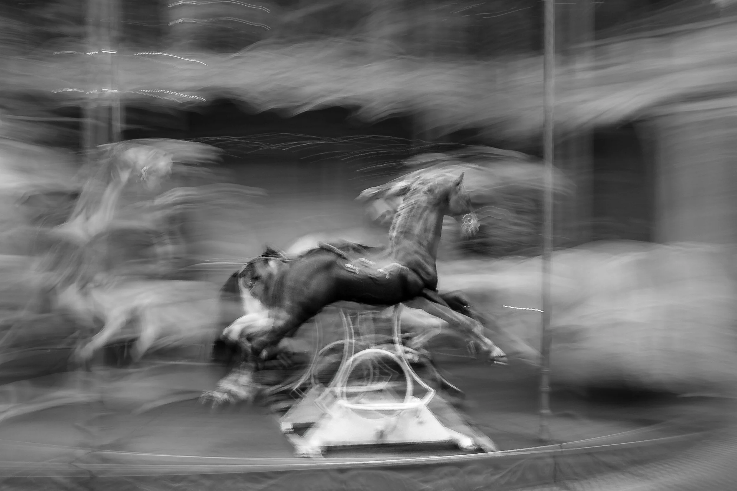 A black and white photo of a dog running on a treadmill, captured with motion blur.