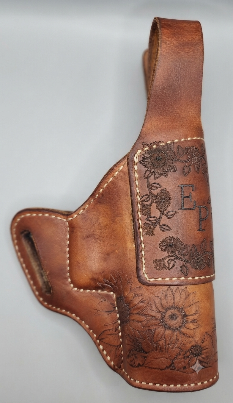 A leather holster with floral engravings and the initials "E P" on the front, designed to hold a handgun.