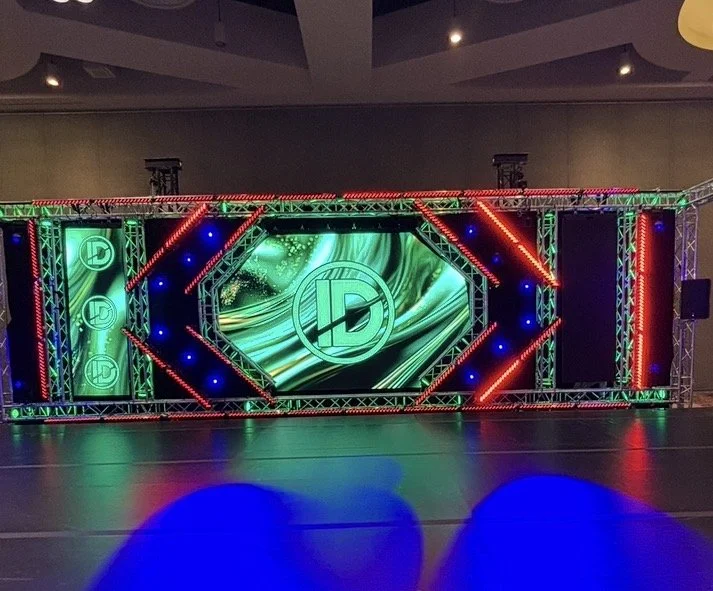 Colorful stage setup with LED lights and a digital screen displaying a logo with the initials 'LD' in the center.