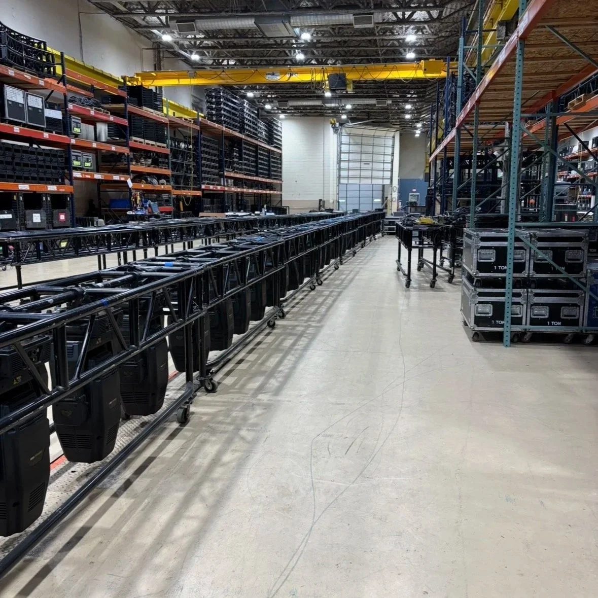 Empty warehouse with carts, shelves, and storage containers organized for equipment or inventory.