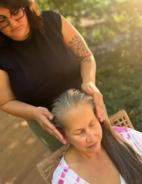Jinae giving outdoor seated Reiki to a client on a sunny day in North Portland