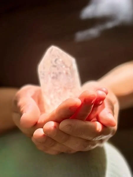Jinae holding a pink crystal stone in her hands.