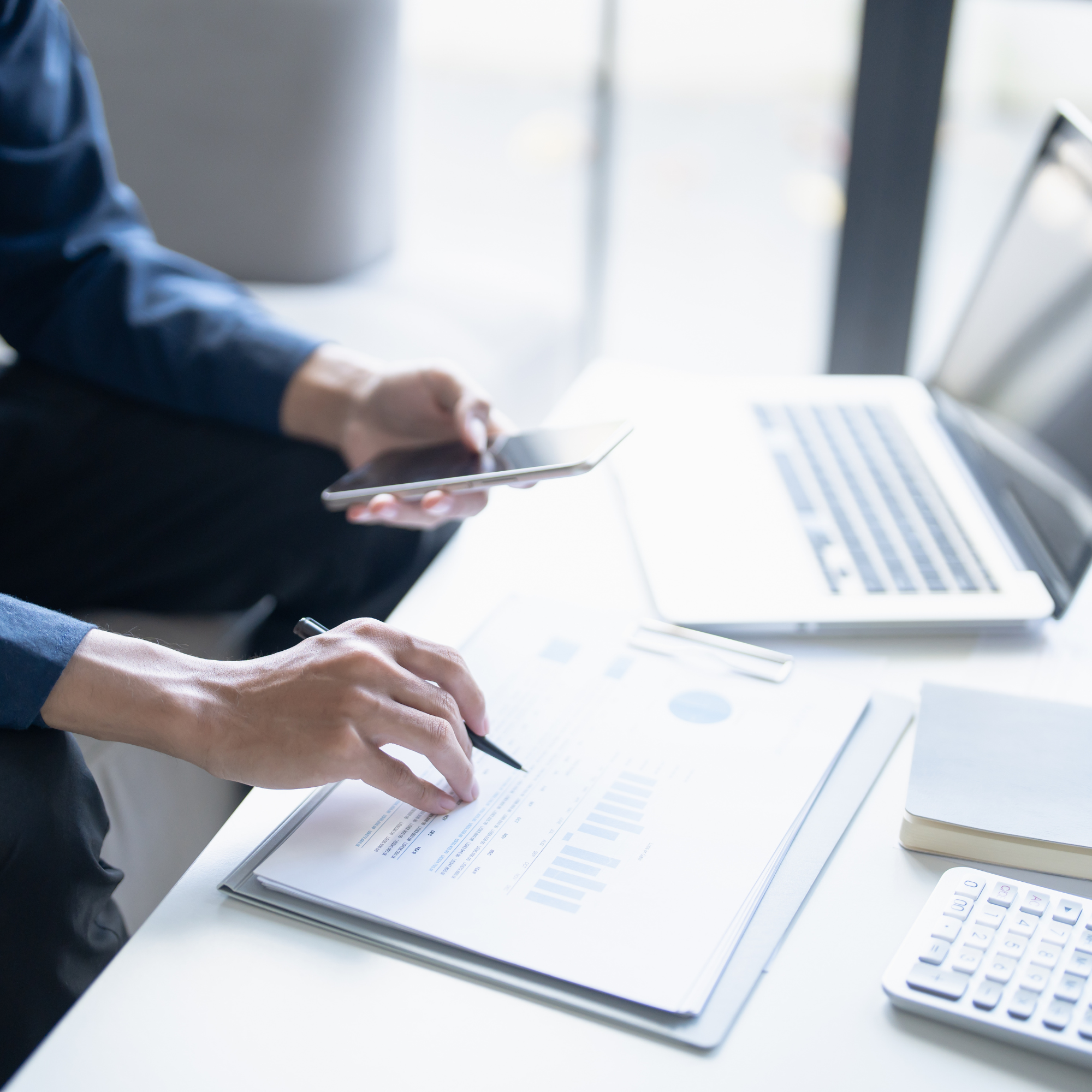 Profesional revisando documentos financieros y registros contables para mantenerse al día con los cambios del IRS y garantizar el cumplimiento de las obligaciones tributarias.