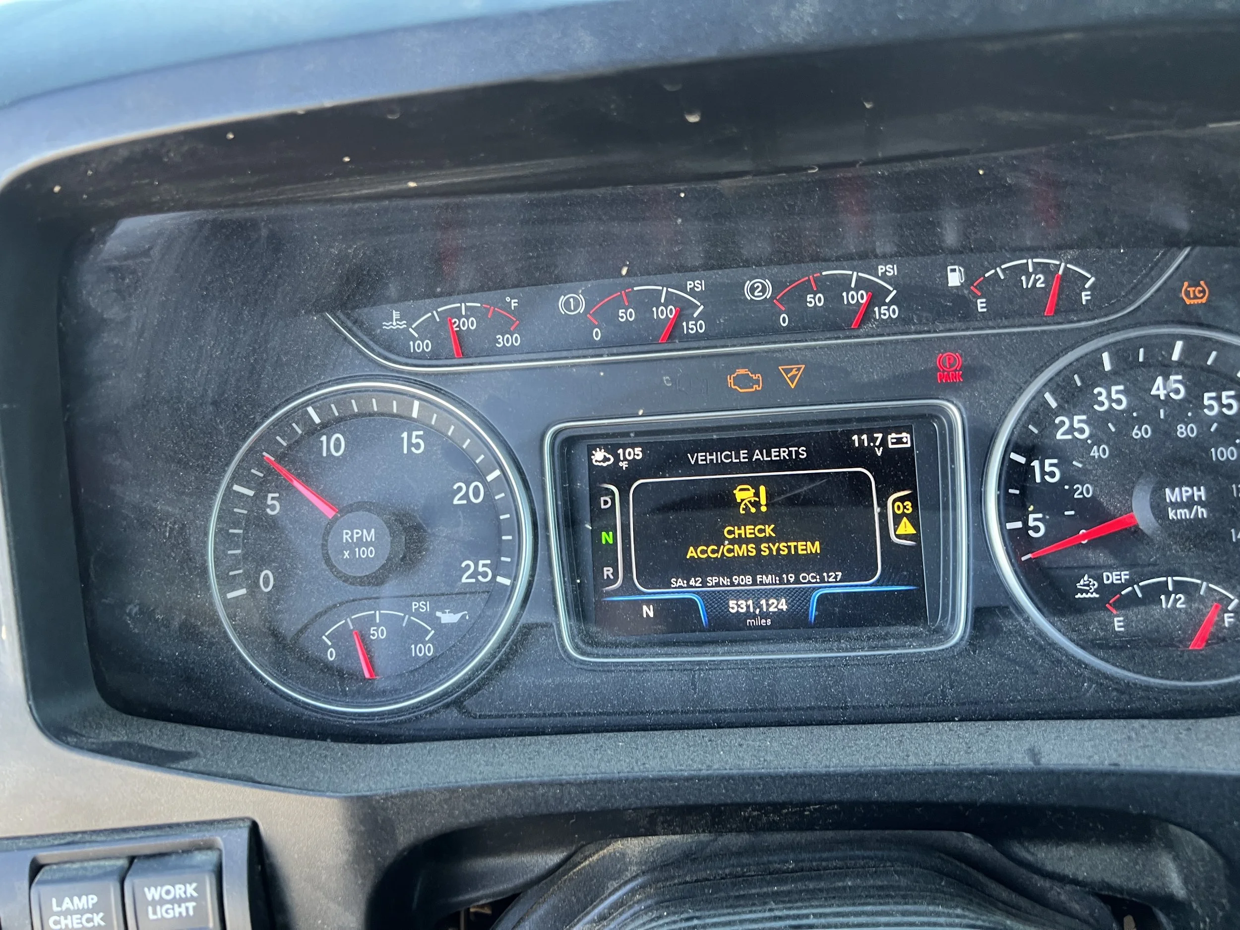 Close-up of a vehicle dashboard showing various gauges, warnings, and alerts, including a check engine indicator, warning lights, and digital information display.