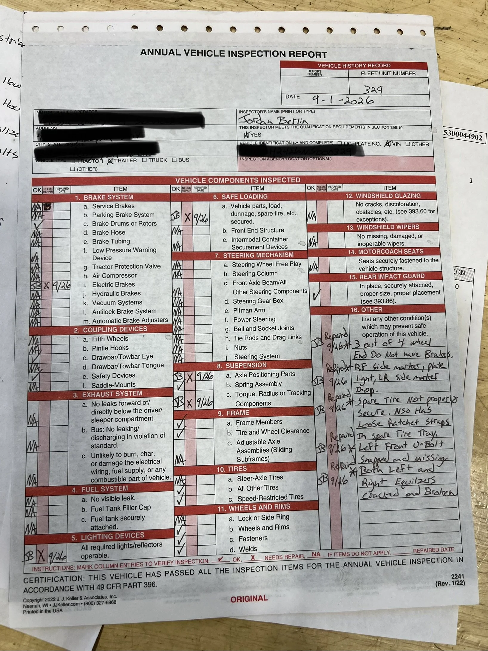 A filled-out vehicle inspection report form with checkmarks and handwritten notes, lying on a wooden surface.
