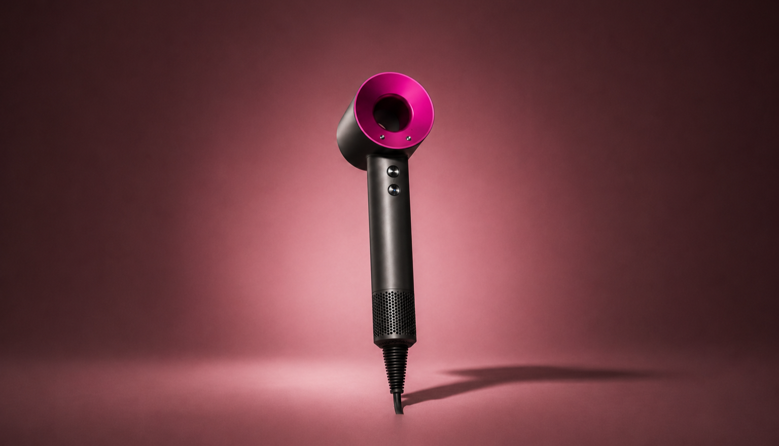 A black and purple hair dryer standing upright against a pink background.