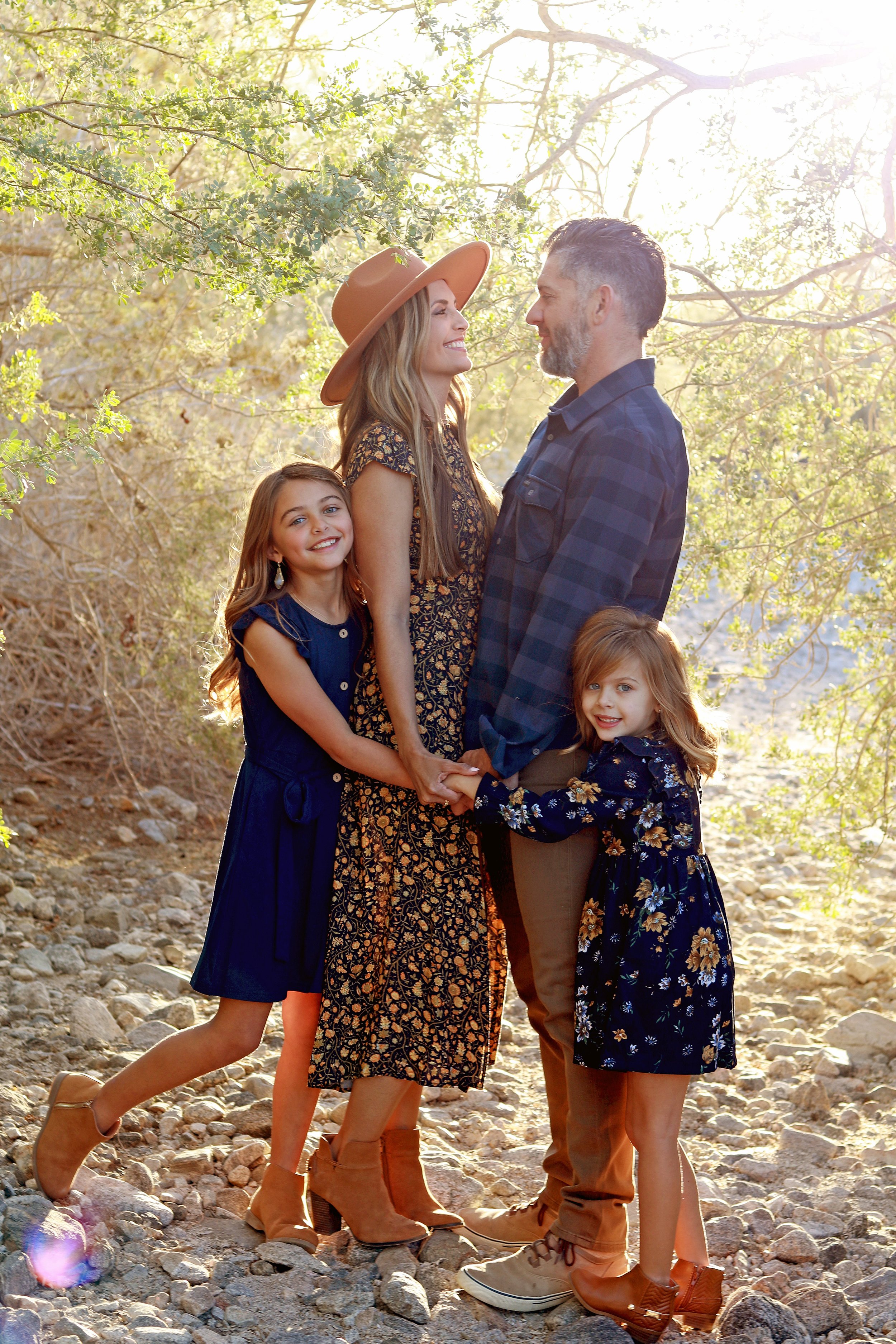 family picture, mom dad and kids, candid, holding hands, desert landscape, golden hour sunlight, navy blue and gold outfits