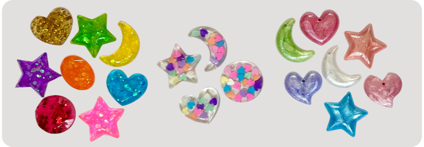 Colorful glitter and confetti shaped like hearts, stars, and moons on a white background.