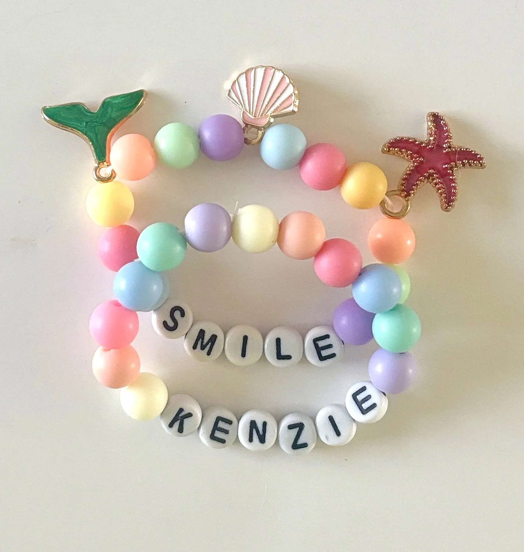 Colorful beaded necklace with starfish, sea shell, and letter beads spelling 'SMILE'.