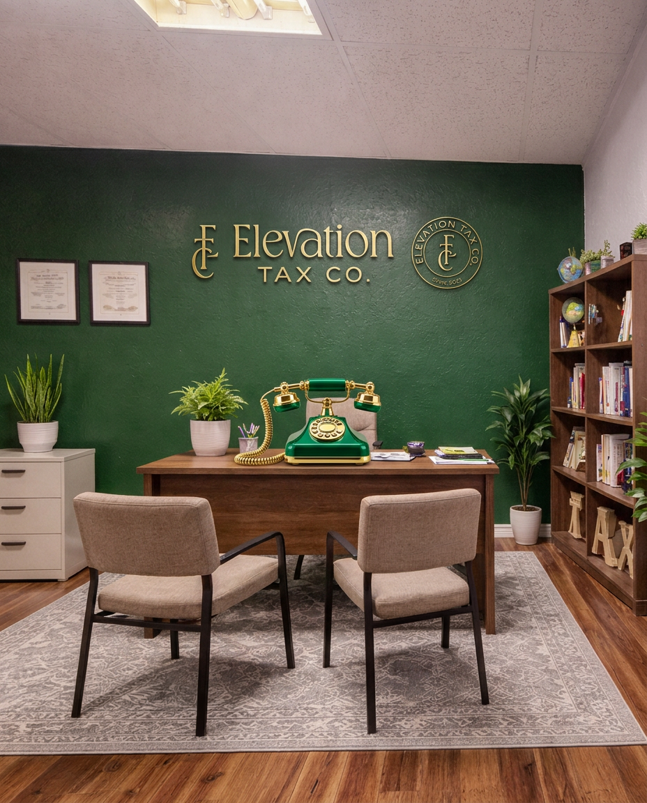 Office reception area with a green wall displaying the text 'Elevation Tax Co.' and a logo, a wooden desk, two beige chairs, a vintage green rotary phone on the desk, potted plants, a bookshelf with books and decorative items, and framed documents on the wall.