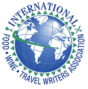 Logo for the International Travel Writers Association featuring a globe with continents and latitude/longitude lines, surrounded by the organization's name.