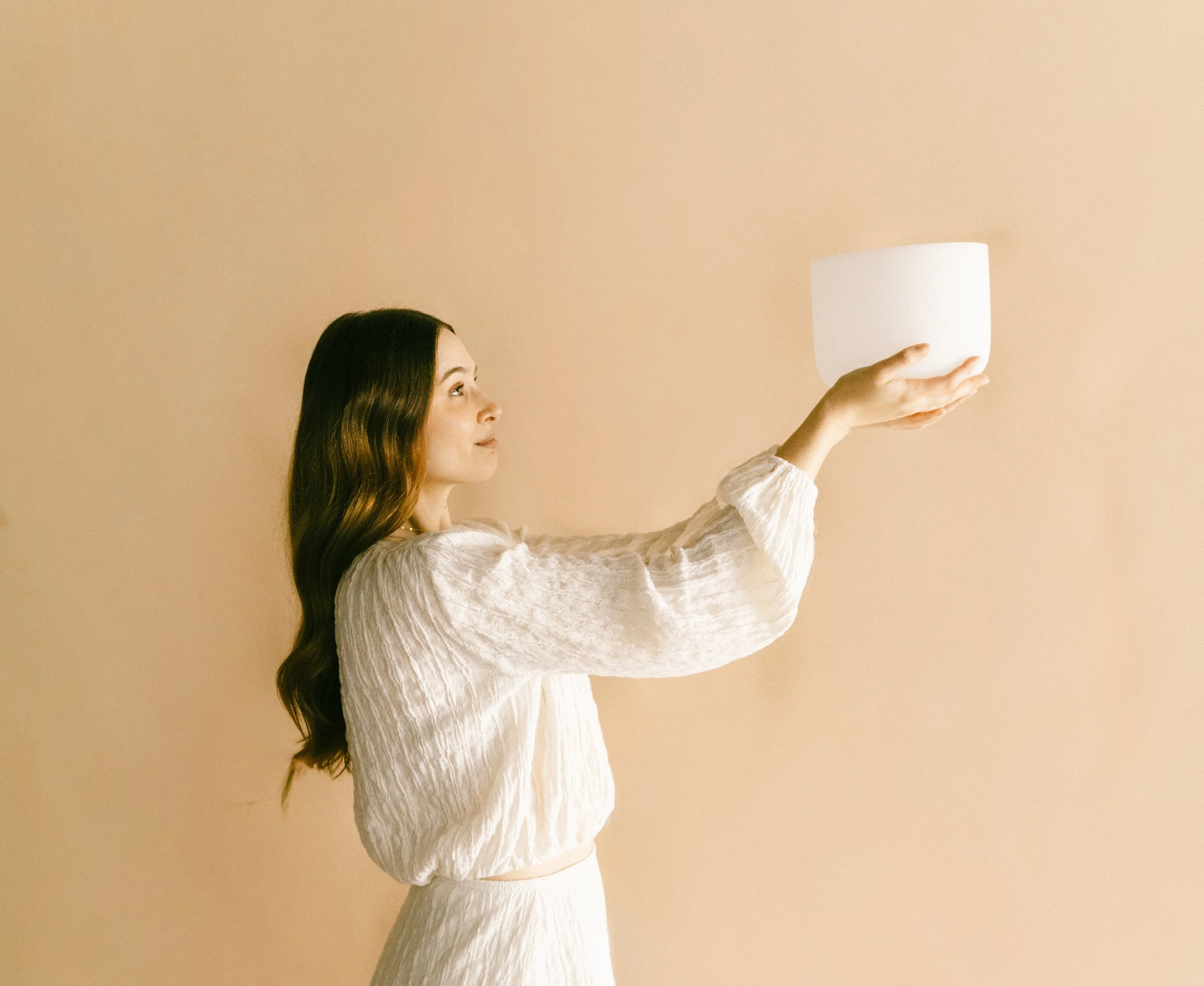 Hannah holding a crystal singing bowl during a sound healing session.