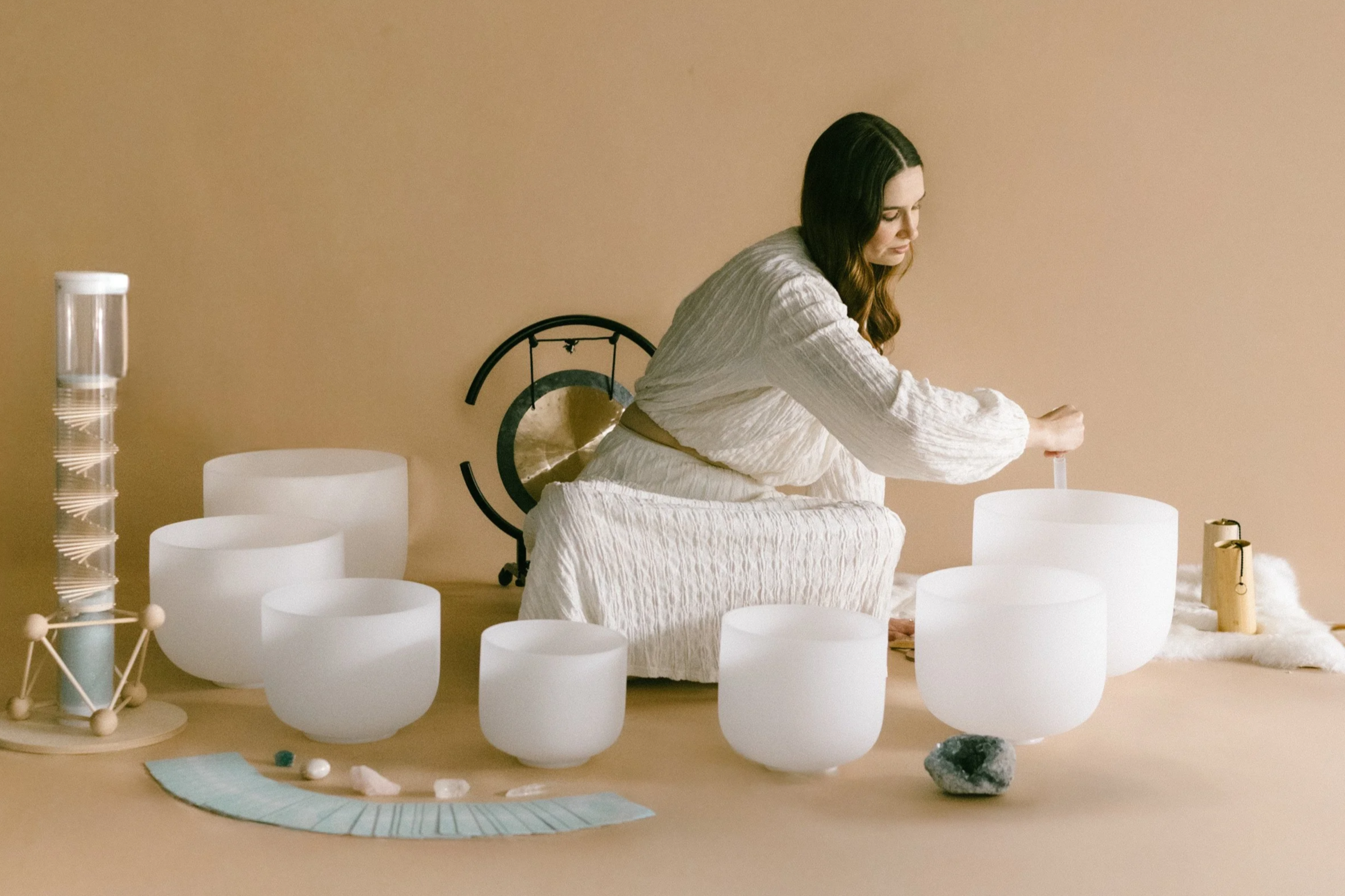Hannah playing crystal singing bowls during a sound bath.