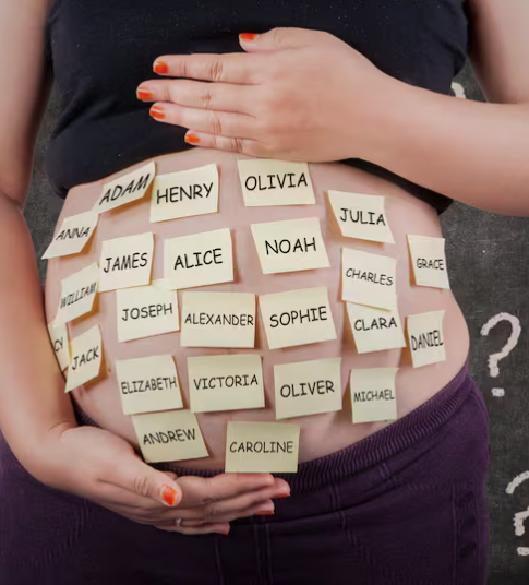 A pregnant person holding their belly, which has multiple name tags placed on it, with one hand resting on top of the belly and the other supporting from underneath.
