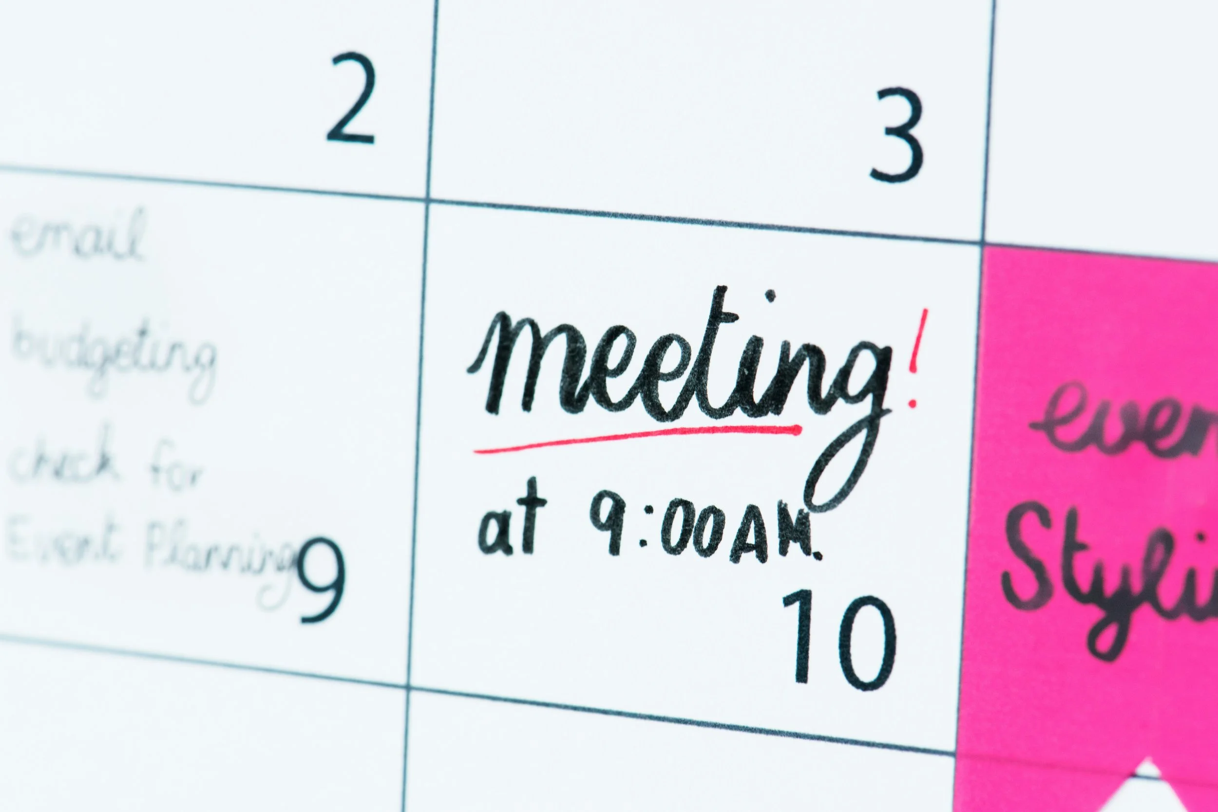 Close-up of a printed calendar or planner page with handwritten notes. The visible part shows the date '2', and the handwritten text 'meeting! at 9:00 AM' is underlined in red.