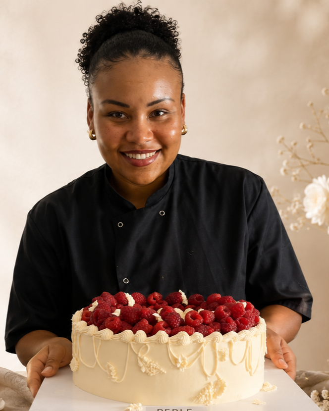 Amandine, fondatrice de perle atelier tenant un gâteau blanc décoré de framboises.