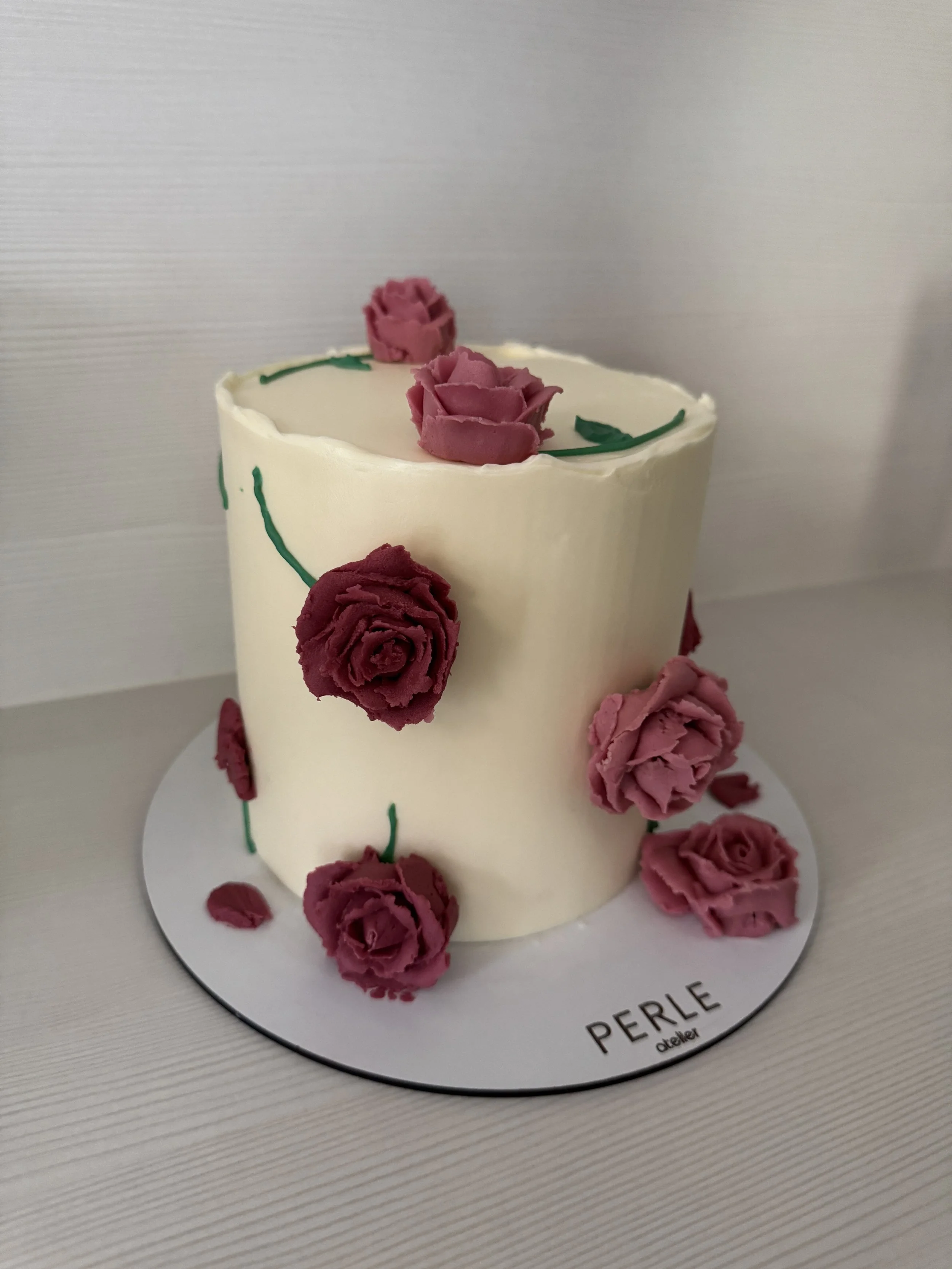 Gâteau blanc décoré de roses en crème au beurre, faite à la main