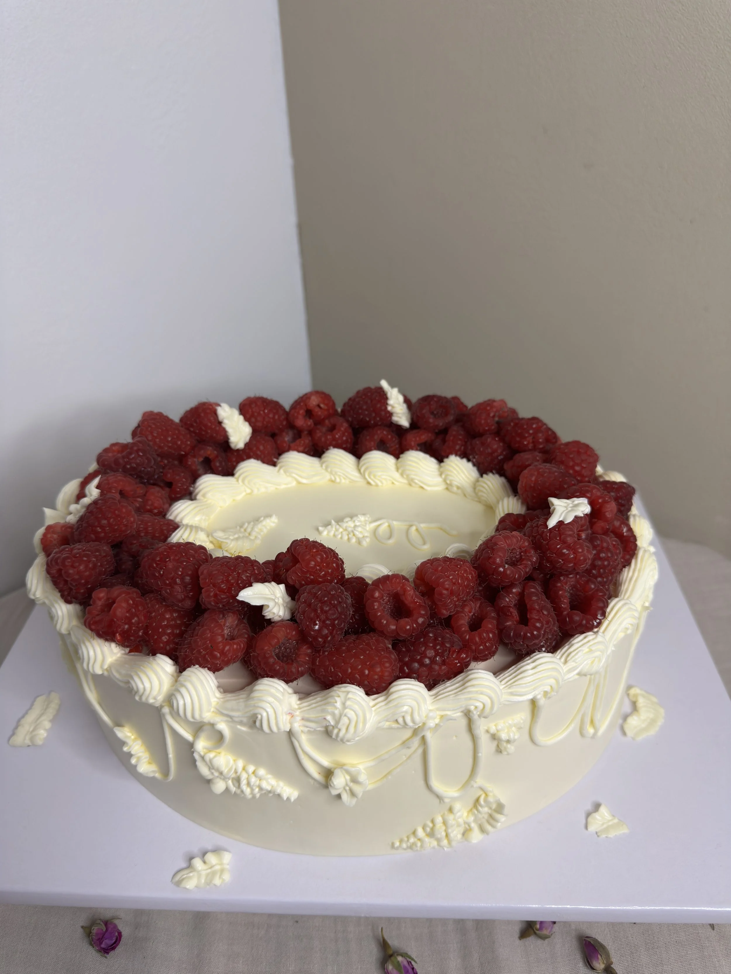 Gâteau décoré avec des framboises fraîches et de crème au beurre