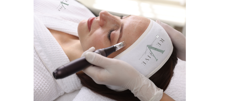 A woman lying on a treatment bed receiving a cosmetic injection in her forehead from a medical professional wearing gloves.